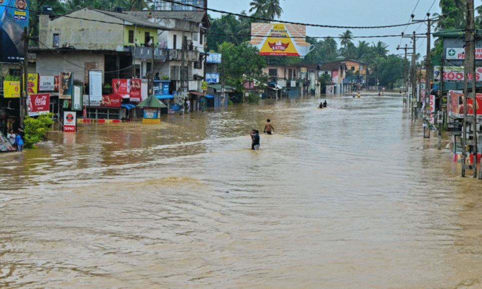 Pessoas atravessam uma rua alagada após fortes chuvas em Kaduwela, nos arredores de Colombo, no Sri Lanka
