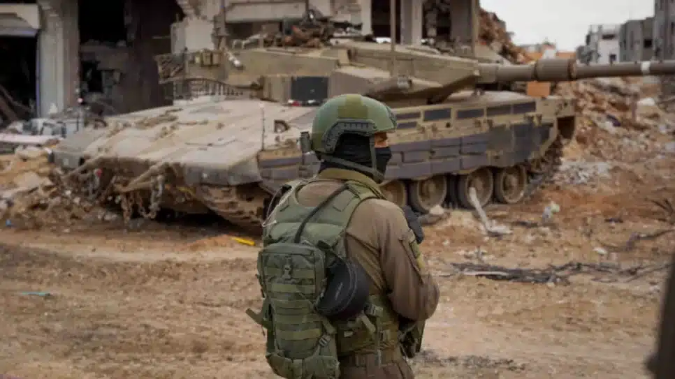 Um soldado israelense observa enquanto Forças de Defesa de Israel operam em Gaza