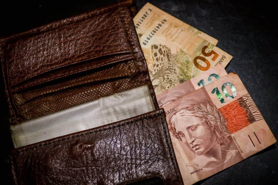 Mão conta notas tiradas da carteira