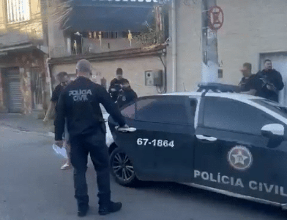 Policiais conduzem o suspeito à viatura