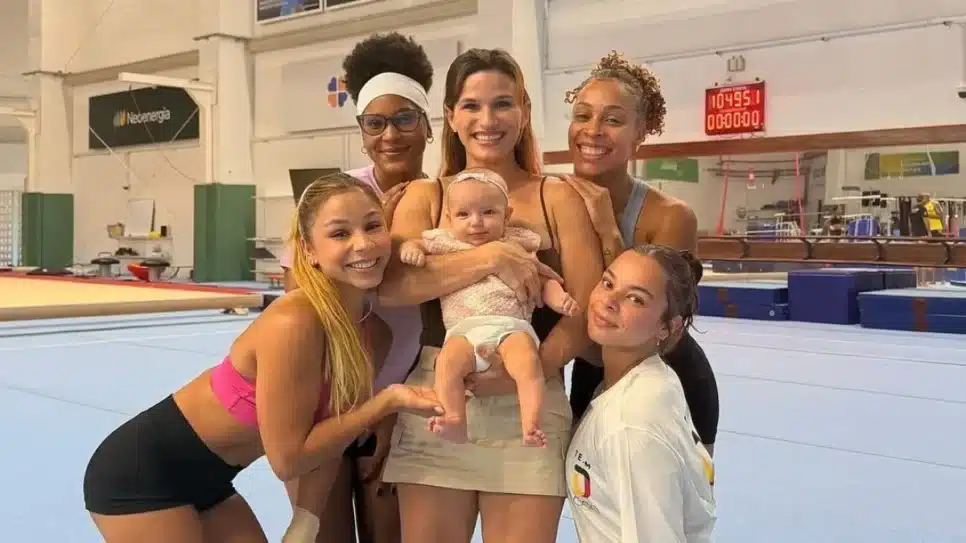 Jade Barbosa com a pequena Eva no colo cercada pela equipe de ginástica do Flamengo