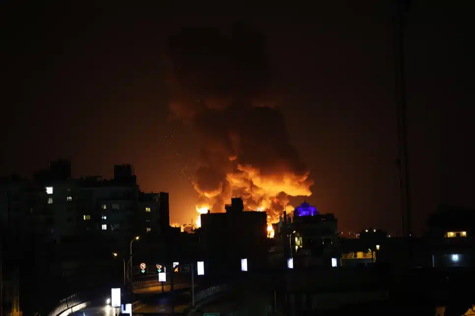 Uma grande coluna de fumaça se eleva sobre Teerã após relatos de explosões na cidade durante a noite de 7 de março de 2026