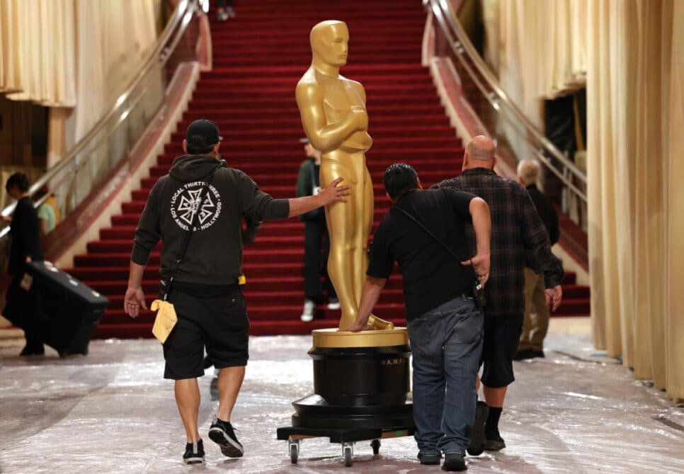 Trabalhadores transportam uma estátua do Oscar no tapete vermelho durante os preparativos para a 97ª cerimônia