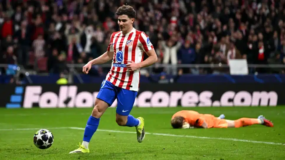 Julián Álvarez, do Atlético de Madrid, finaliza para o gol vazio, enquanto o goleiro Antonin Kinsky, do Tottenham, lamenta a falha deitado no gramado; o Atleti venceu a partida de goleada