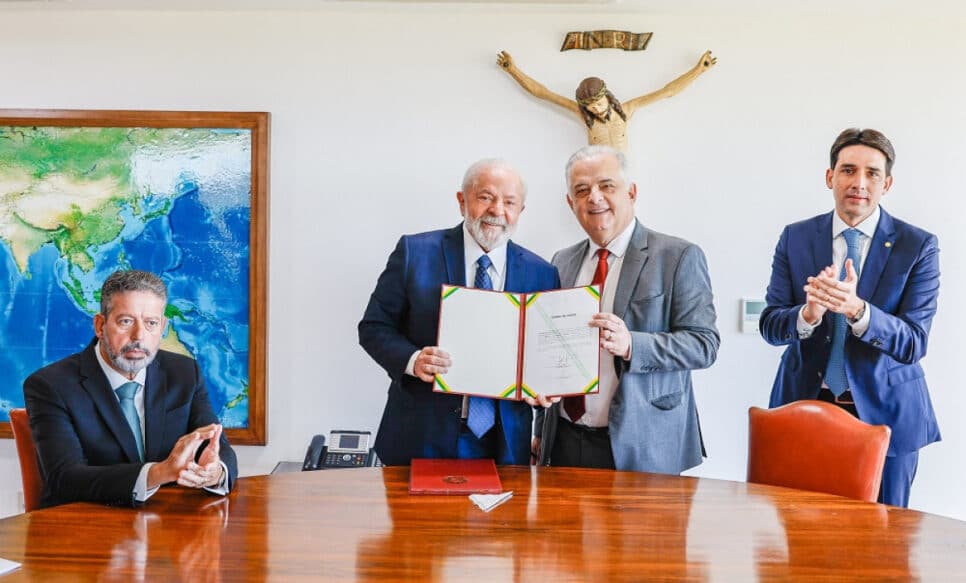 Lula e Márcio FRança exibem diploma do nvo ministro, enquanto Silvio Costa filho aplau de pé,. e Arthur Lira, sentado