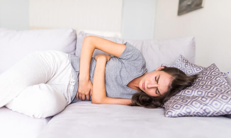 Mulher sofre com dores provocadas pela menstruação